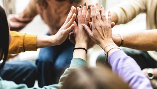 group-stacking-hands-together-GettyImages-1496112689-3000x2000.jpg