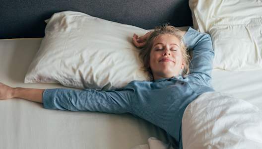 woman-stretches-in-bed-GettyImages-1211550652-3000x2000.jpg