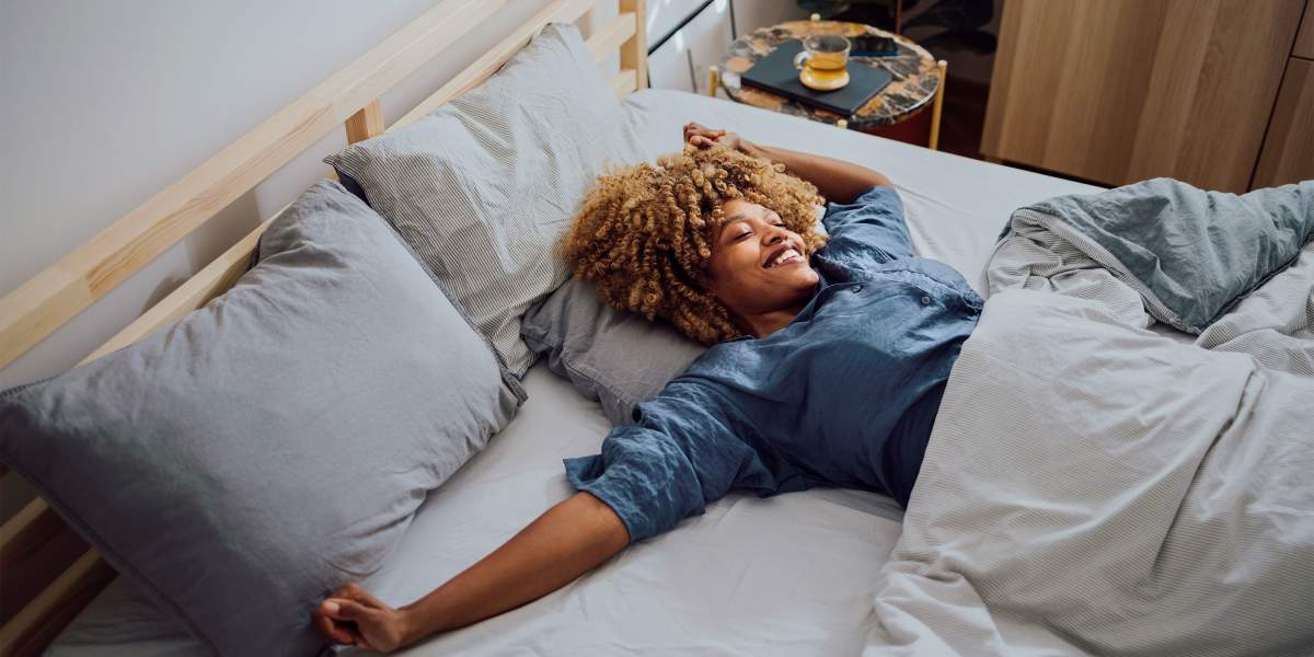 woman-stretches-in-bed-GettyImages-1370783732-3000x2000.jpg