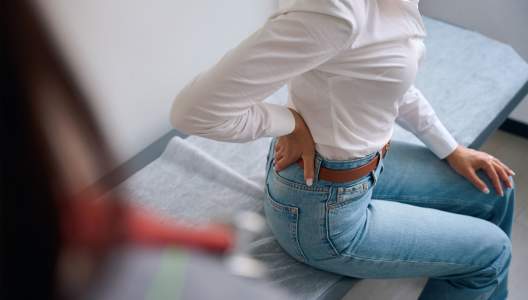woman-with-backache-in-doctor-office-GettyImages-1799926233-3000x2000.jpg